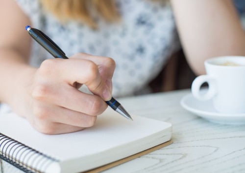 businesswoman with a note-book in a cafe drinking coffee
